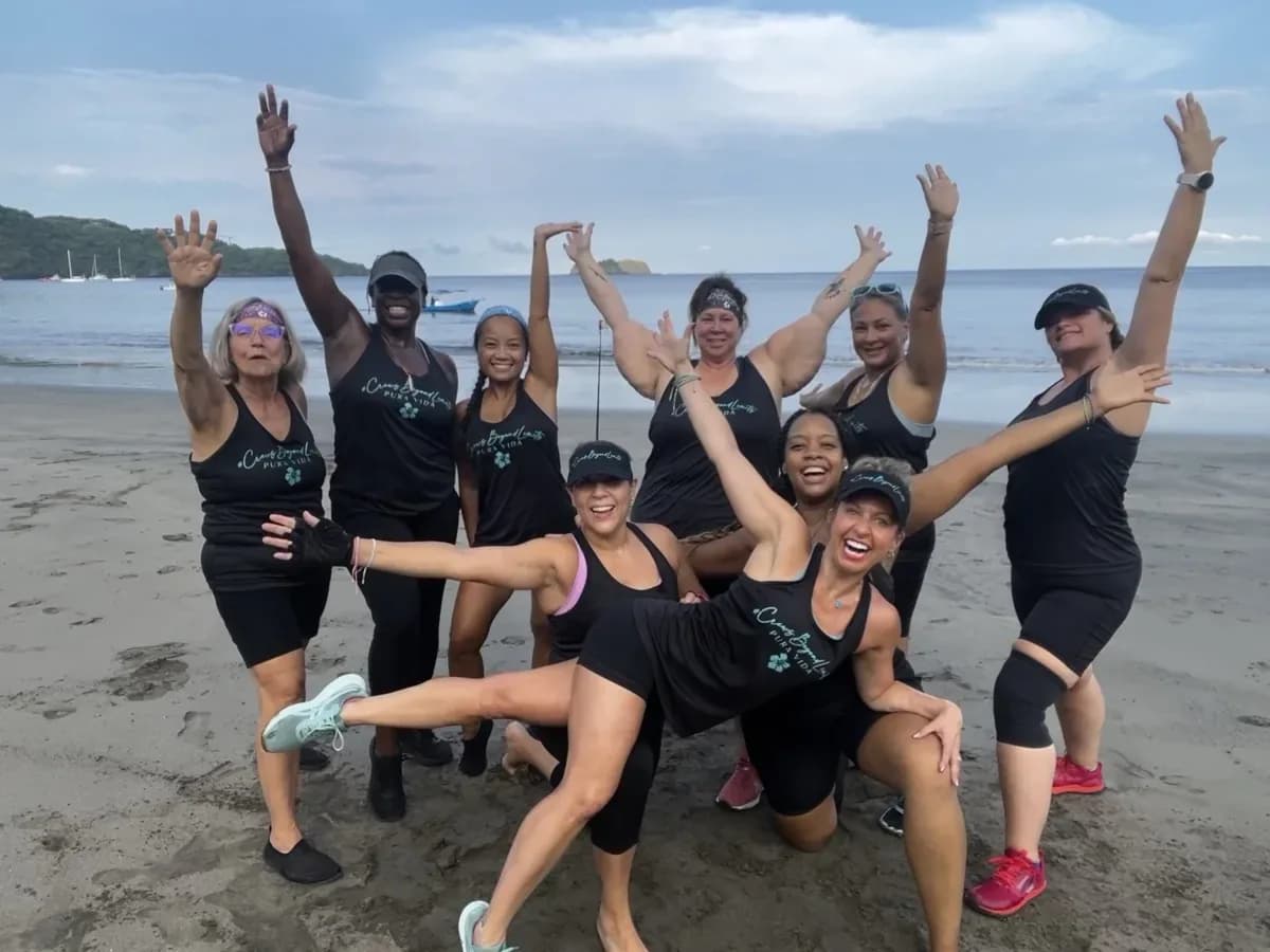 Health Mastery members celebrating together after a beach workout